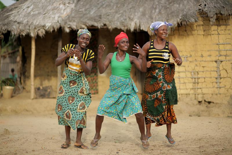 3 women dance in celebration at the news that the Government will support them in protecting their land from being grabbed by the palm oil company Equatorial Palm Oil.